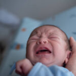 newborn crying on changing mat