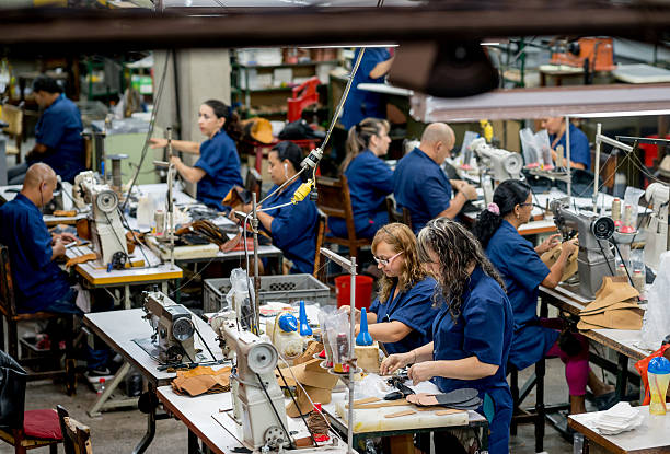 Group of Latin American manual workers working at a shoe-making factory