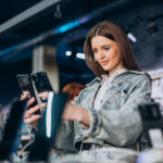 Woman choosing phone at technology store