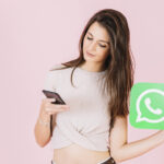 beautiful-young-woman-holding-whatsapp-icon-using-mobile-phone (1)